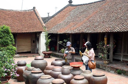 Tourists visiting an old house in Duong Lam Ancient Village
