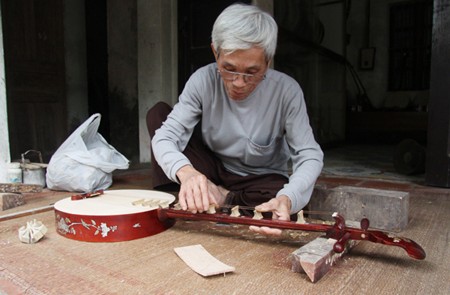 Artisan adjusting the strings of the instrument