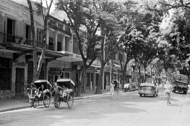 Street scene with shops and rickshaws in Hanoi