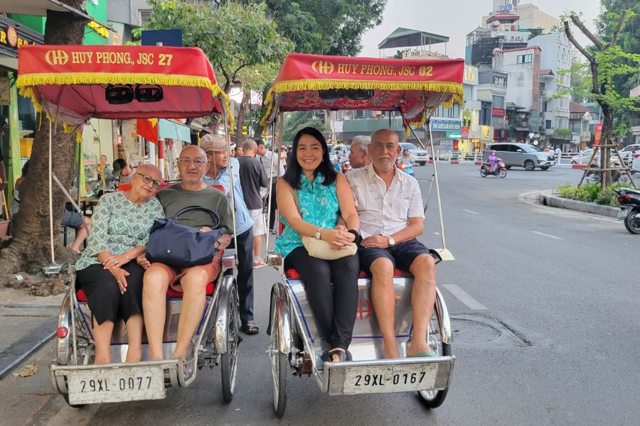 Tourists enjoying a cyclo ride through Hanoi Tours